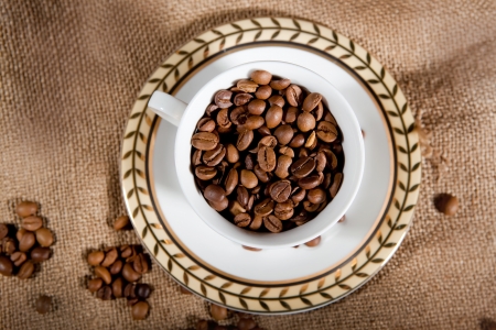 a cup wit coffee beans on the sackの写真素材