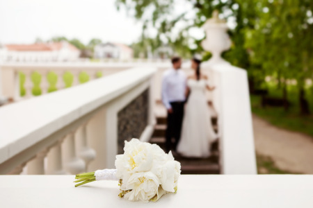 wedding bouquet with peonies in front of bride and groomの写真素材