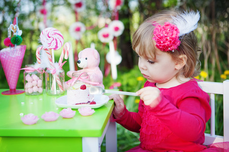 little girl is eating cakeの写真素材