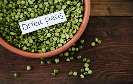 Dry green peas in a bowl. Split green peas. Peas on a wooden background. side view. Lettering green...