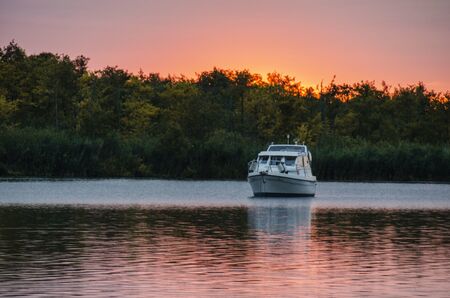 Yacht on a lake during sunsetの写真素材