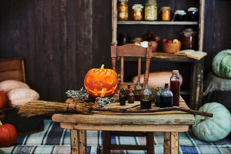 Old wooden table, orange hallowen pumpkin, dried herbs and bottles, a top view, in the studio, in the afternoon.の写真素材