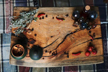 old wooden table with dried herbs and bottles, a top view, in the studio, in the afternoon in studio.の写真素材