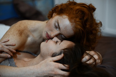 the lovers lay on the bed and gently huggingの写真素材