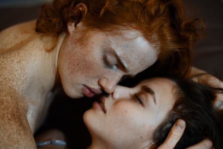 the lovers lay on the bed and gently huggingの写真素材