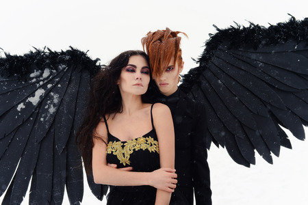 a cute girl with a man , a black angel on the lake, white snowの写真素材
