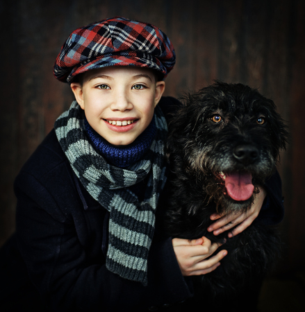 boy with a dog vintage costume posing on black backgroundの写真素材