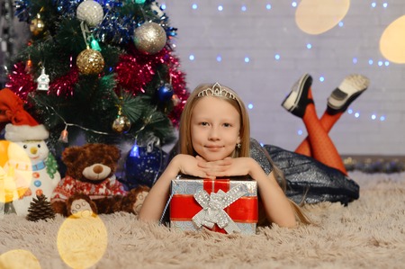 girl near Christmas tree with gifts on grey background. new yearの写真素材