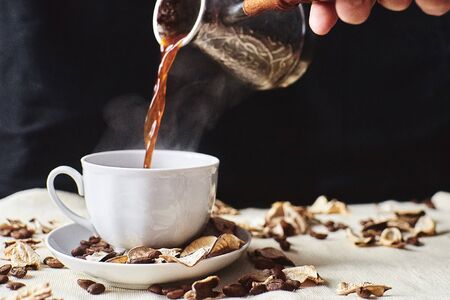 Espresso coffee drink is poured into a white steamed Cup	の写真素材