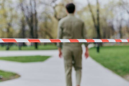 The man goes behind the security tape. Violation of the ban on walking in public placesの写真素材
