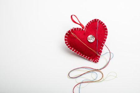Heart shaped pincushion with a needle and thread.の写真素材