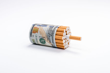 Smoking and money cost. Cigarettes wrapped in hundred dollars banknotes on white background. Waste...