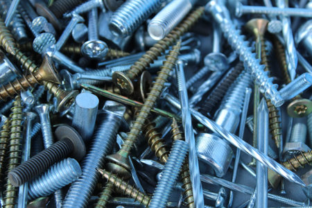 construction background bolts nuts screws nails silver white and yellow fittings close up