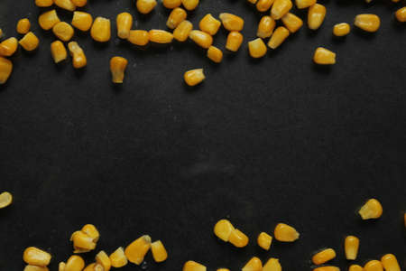 food background bright sugar yellow corn at the edges of the top right or from bottom to top on black background copy spaceの写真素材