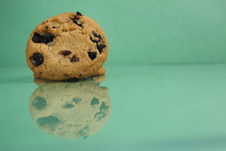 food background cookies round with chocolate drops lying with a reflection on a green grass...