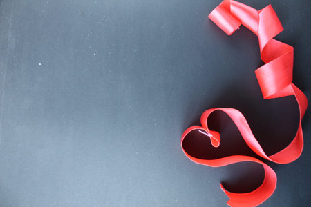 red heart of tape with curls on black gray background with copyspace place for text valentine's day.の写真素材