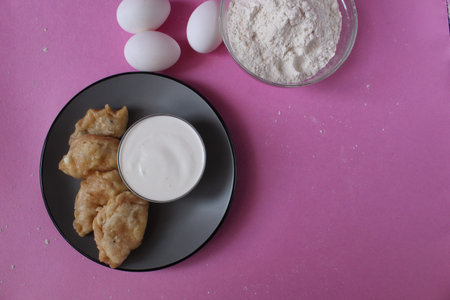 boiled dumplings lie on a gray plate with sour cream on a pink background cooking the traditional dish of slavic copyspace place for text.の写真素材