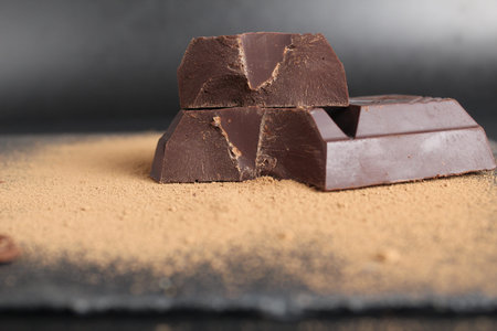 macro day chocolate two large chopped pieces of chocolate on a black background close-up.