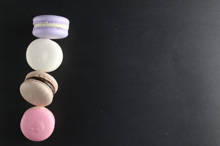 Four macaroons view from above on a black background with a place for text and with copyspace cooking.の写真素材