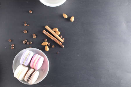 flat lay macaroons sticks of cinnamon coffee beans on a black background view from above with a place to text the copyspace.の写真素材