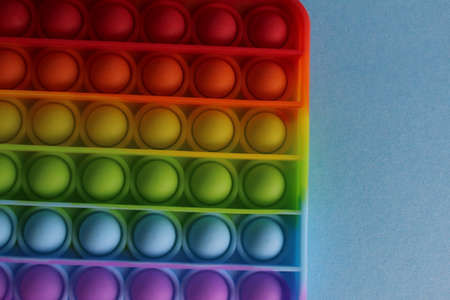 The anti-stress toy popit simple dimple on a blue background with a place for text and with a copypispe. View from above.の写真素材