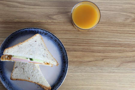 Breakfast snack lunch two sandwiches on a plate and a glass of juice on the table. Kind of super. Flat lay.の写真素材