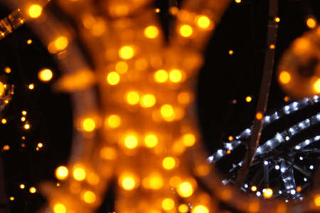 yellow lights on a dark black background. New Year's Eve Christmas background. Festive lighting.の写真素材