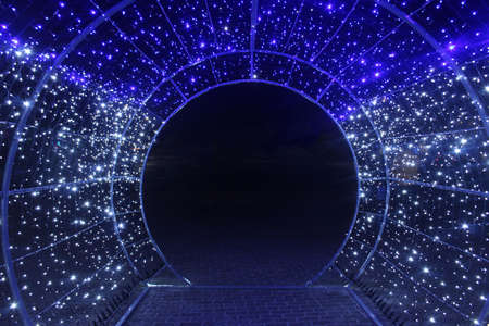 tunnel and illuminations of blue white on a black dark background. New Year's Eve Christmas. Photoona festive atmosphere.の素材 [FY310171958566]