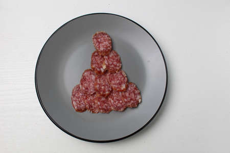 edible Christmas tree spruce from sausage salami meat on a gray plate on a white light background with space for text and copyspace.の写真素材