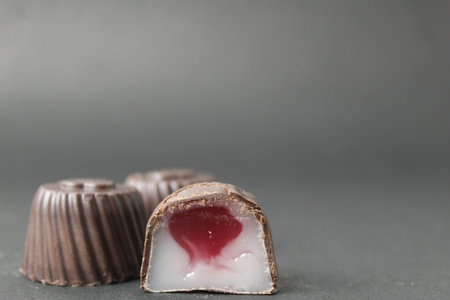 chocolate case candy with a marmalade filling of jelly and a red white middle with cherries and a...