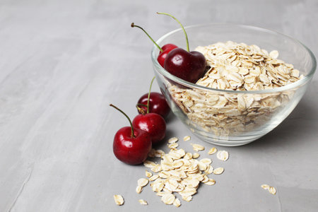 oatmeal oatmeal porridge in a glass plate bowl bowl with cherry berries on a gray background with space for text and copyspace. healthy diet food.の写真素材