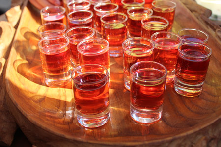 red drink, juice, tincture, alcohol in small glasses, glasses. alcoholic beverages alcoholism homemade alcohol treats traditionsの写真素材