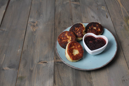 Cheesecakes on a plate. Breakfast for two on a gray background with space for copy space text. Vegetarian cottage cheese dishes.の写真素材