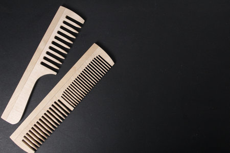 Two wooden combs lie on a black background with space for copyspace text. Natural Wood Products.の写真素材