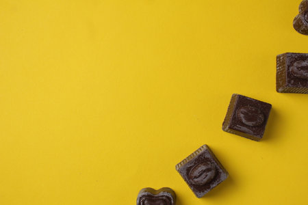 Chocolates lie in a row top view on a yellow background with space for copy space text.の写真素材