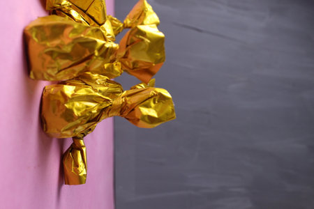 Chocolates on a gray background close-up. Sweets in a golden yellow wrapper.の写真素材