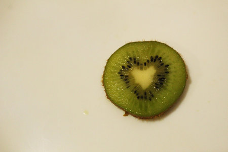 Heart-shaped kiwi cut close-up spot for copyspace text.の写真素材