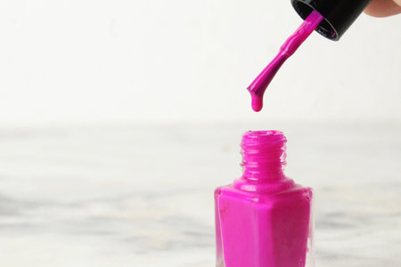 Picking up nail polish with a brush close-up on a white light background space for text copyspace.の写真素材
