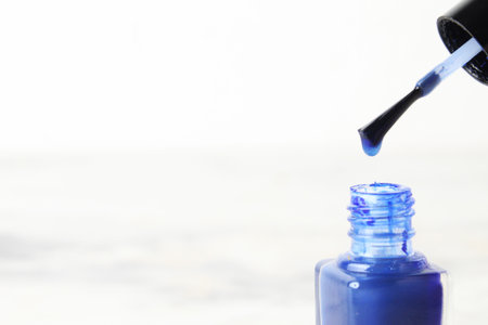 Very close-up bottle of nail polish on light white background copyspace.の写真素材