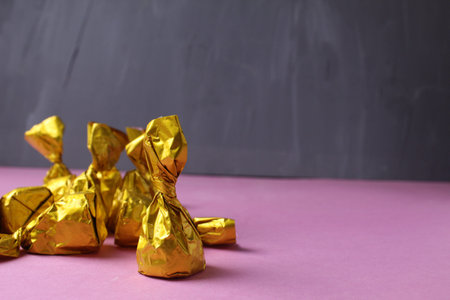 Candy on a pink background. The process of wrapping candies. Homemade sweets