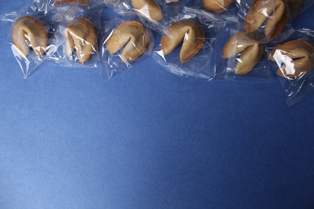 Tasty fortune cookies with predictions on dark blue background, flat lay. Space for text.の写真素材