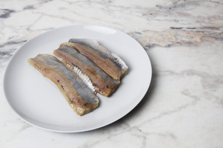 Herring fillet on a plate with space for copyspace text.