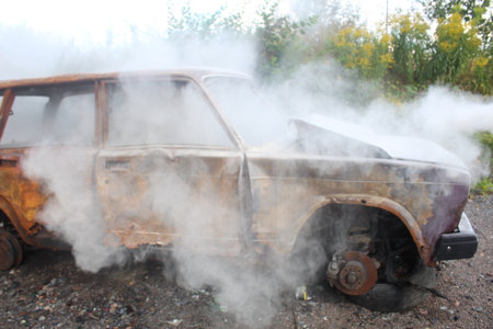 A car catches fire on the street. Fire and fire extinguishing in transport. Summer.の写真素材