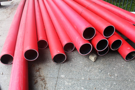 Red communication pipes close-up. Laying of communications.