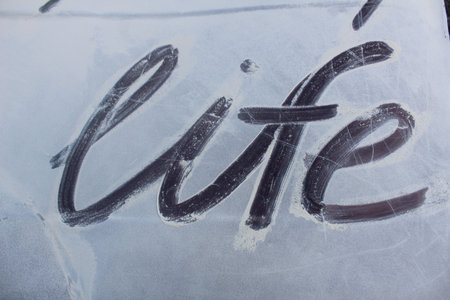 Word life on a white background of snow dust foam close-up.の写真素材