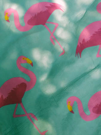 Pink flamingo mint picnic blanket. Summer vibes in park or garden, sun is shining through the trees.の写真素材