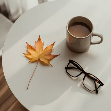 Coffee mug leaf glasses are arranged together on a white table with soft sunlight in a simple sceneの素材
