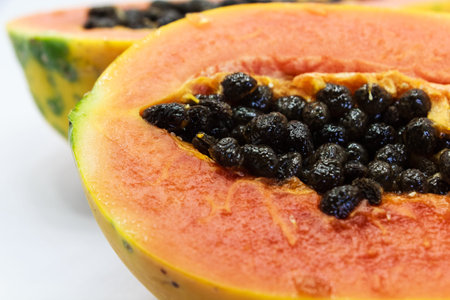 halved fresh papaya fruit isolated on white background