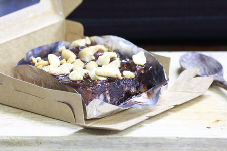 chocolate cake in a paper box on a wooden table, selective focus