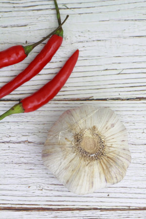 Garlic and red hot chili peppers on rustic white wood backgroundの写真素材